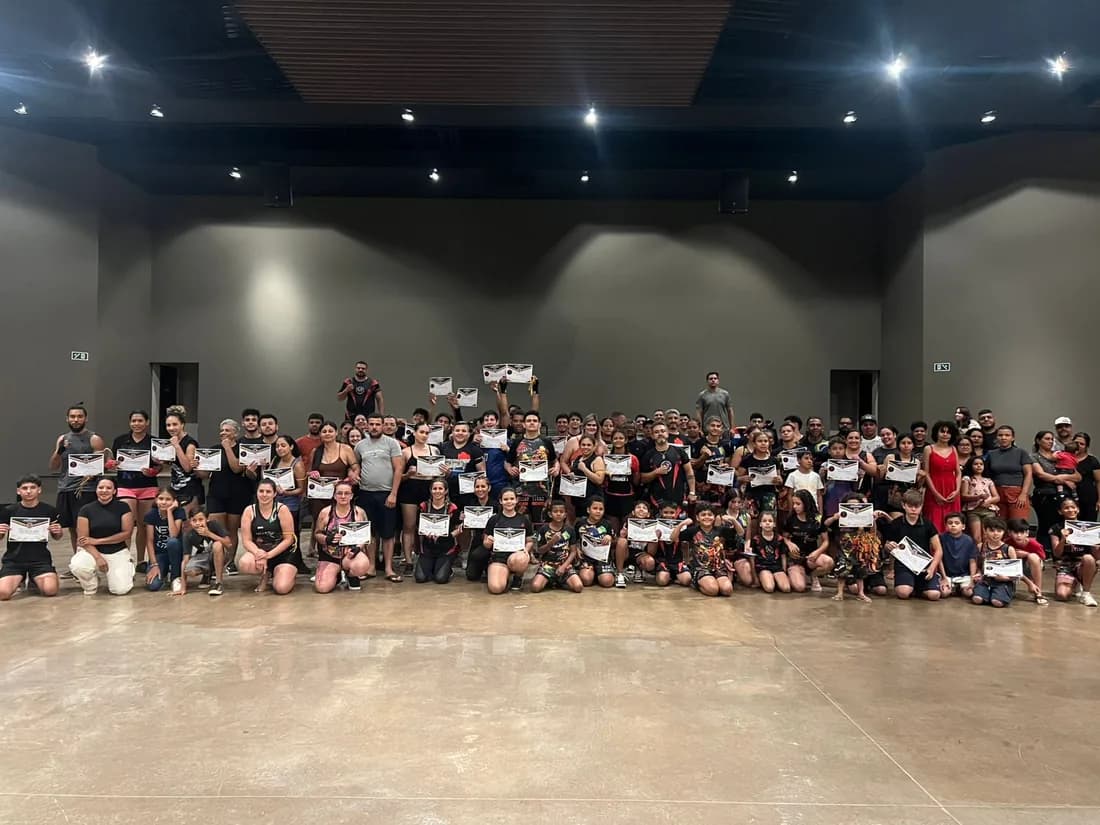 Cerimônia de graduação coletiva da Equipe FFT com dezenas de alunos segurando seus certificados