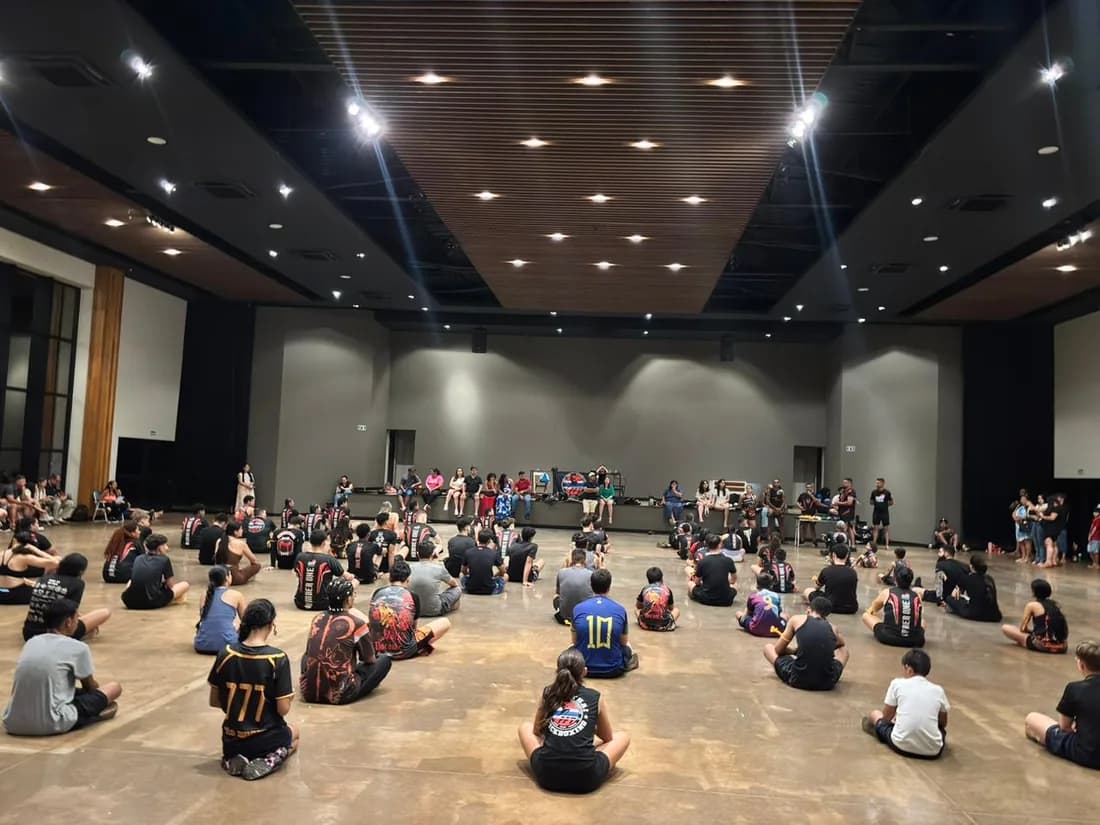 Seminário da Equipe FFT com dezenas de alunos sentados em roda assistindo à demonstração no centro