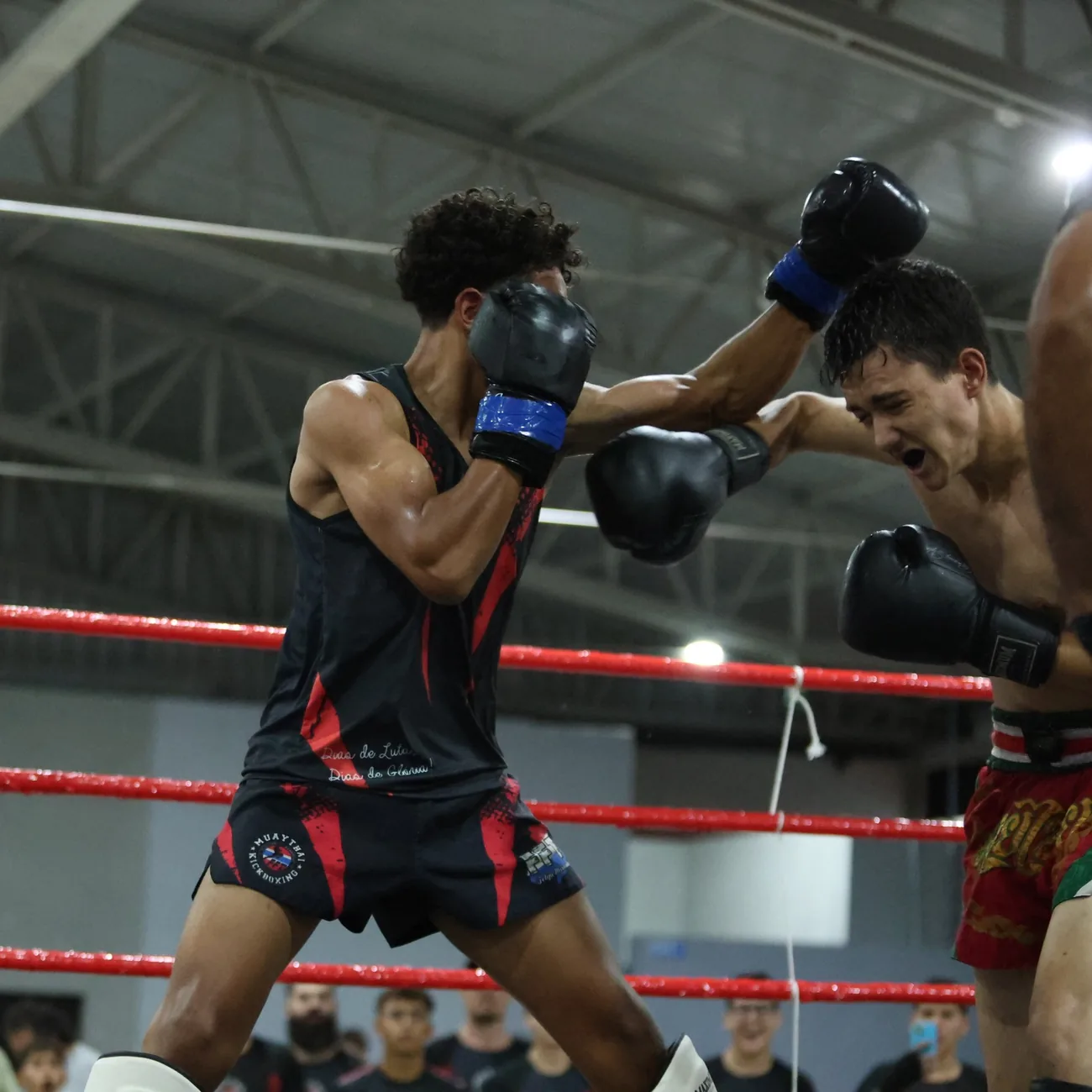 Lutador da Equipe FFT trocando golpes com o adversário no ringue durante campeonato de kickboxing